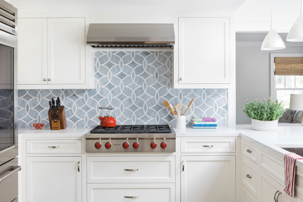 Design ideas for a transitional u-shaped kitchen in Boston with a drop-in sink, white cabinets, quartz benchtops, grey splashback, glass tile splashback, with island, recessed-panel cabinets, stainless steel appliances and cork floors.