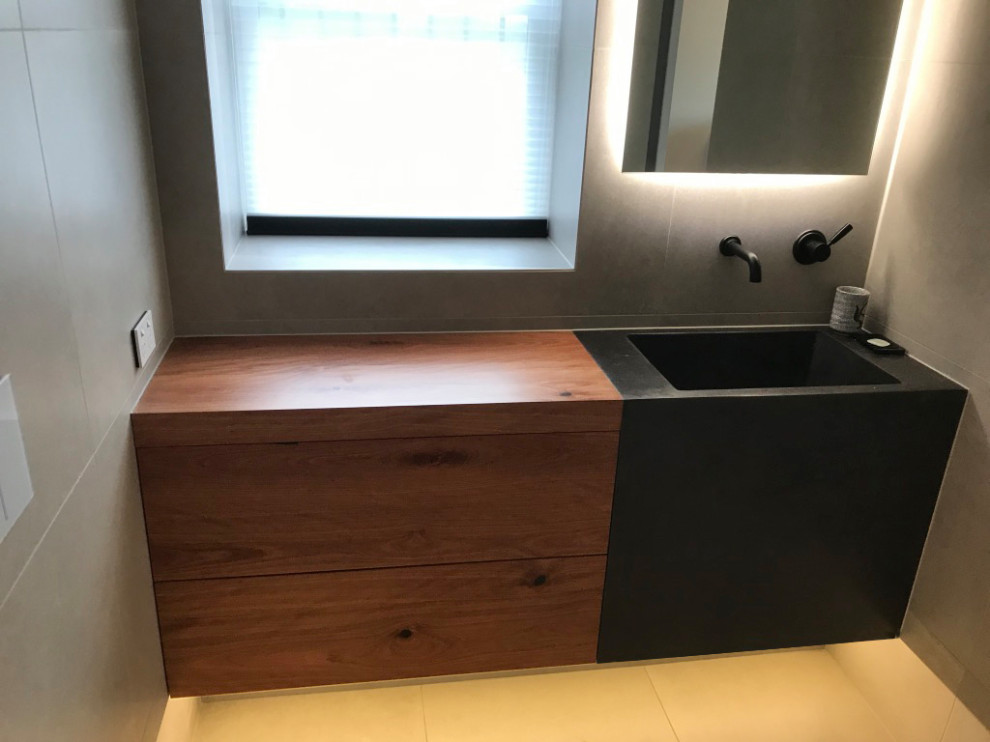 This is an example of a contemporary master bathroom in Newcastle - Maitland with furniture-like cabinets and concrete benchtops.