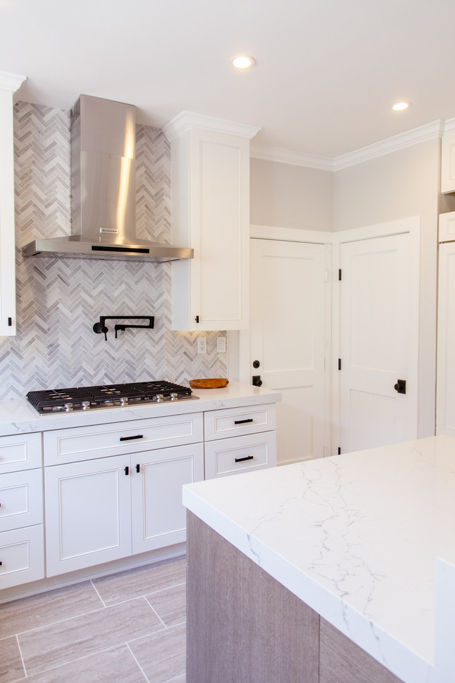Photo of a mid-sized contemporary l-shaped eat-in kitchen in Orange County with an undermount sink, shaker cabinets, white cabinets, marble benchtops, grey splashback, porcelain floors, with island, mosaic tile splashback, stainless steel appliances and grey floor.
