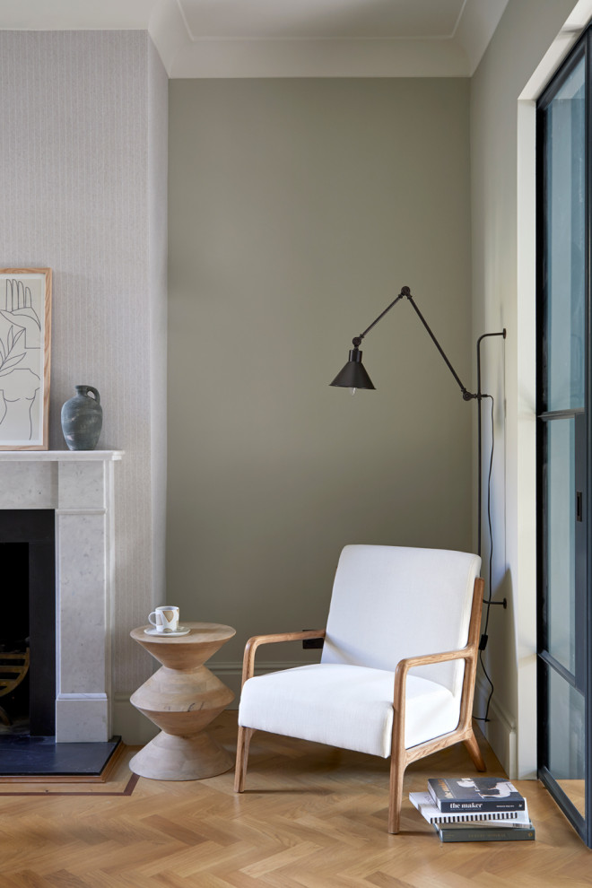 Cette image montre un grand bureau design avec un mur vert, une cheminée standard, un sol en bois brun, un manteau de cheminée en pierre, un bureau indépendant et du papier peint.