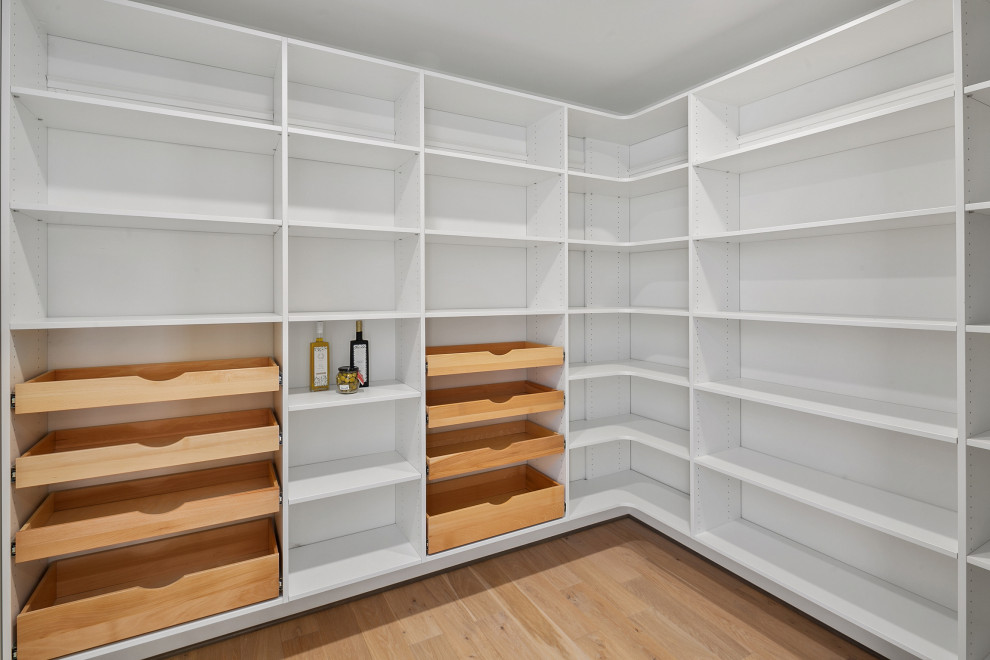 Diseño de armario vestidor unisex campestre grande con suelo de madera clara, armarios abiertos, puertas de armario blancas y suelo marrón