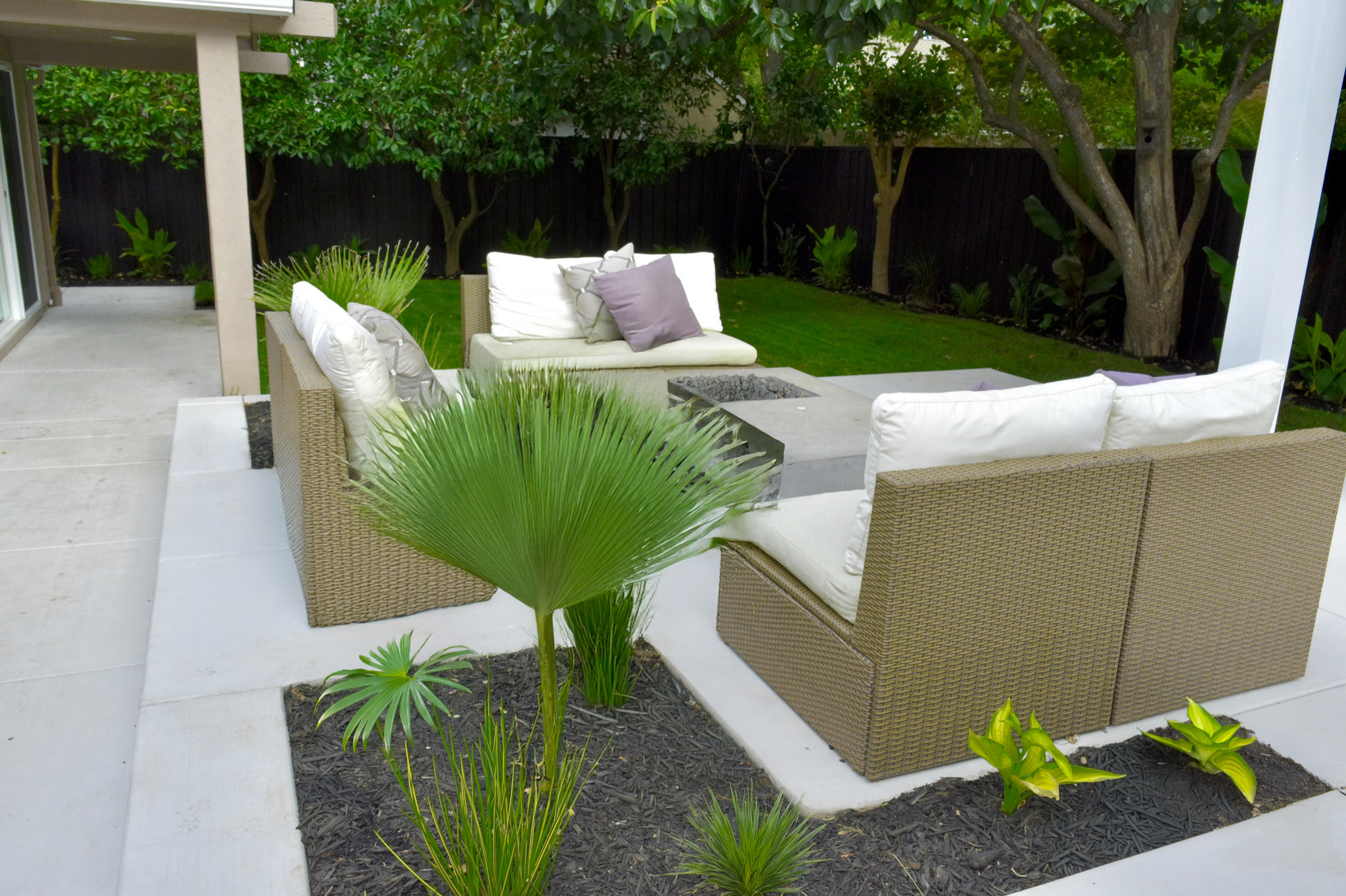 Modern Tropical Seating Area with Firepit and Privacy Greenery