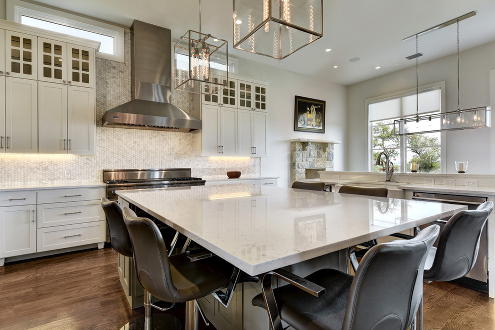 Design ideas for a large transitional u-shaped eat-in kitchen in Austin with shaker cabinets, white cabinets, white splashback, mosaic tile splashback, stainless steel appliances, dark hardwood floors, with island, quartz benchtops and a farmhouse sink.