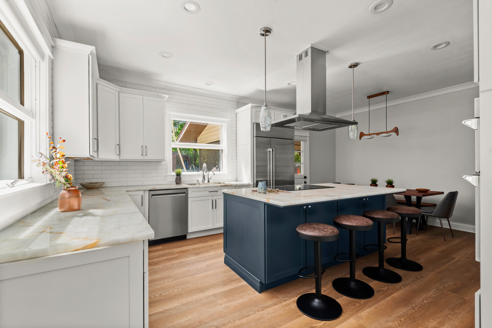 Design ideas for a medium sized contemporary l-shaped kitchen/diner in Tampa with a submerged sink, shaker cabinets, blue cabinets, engineered stone countertops, white splashback, ceramic splashback, stainless steel appliances, vinyl flooring, an island, brown floors and beige worktops.