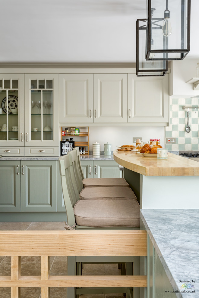 Photo of a transitional kitchen in Cambridgeshire with a farmhouse sink, shaker cabinets, green cabinets, marble benchtops, ceramic splashback and limestone floors.
