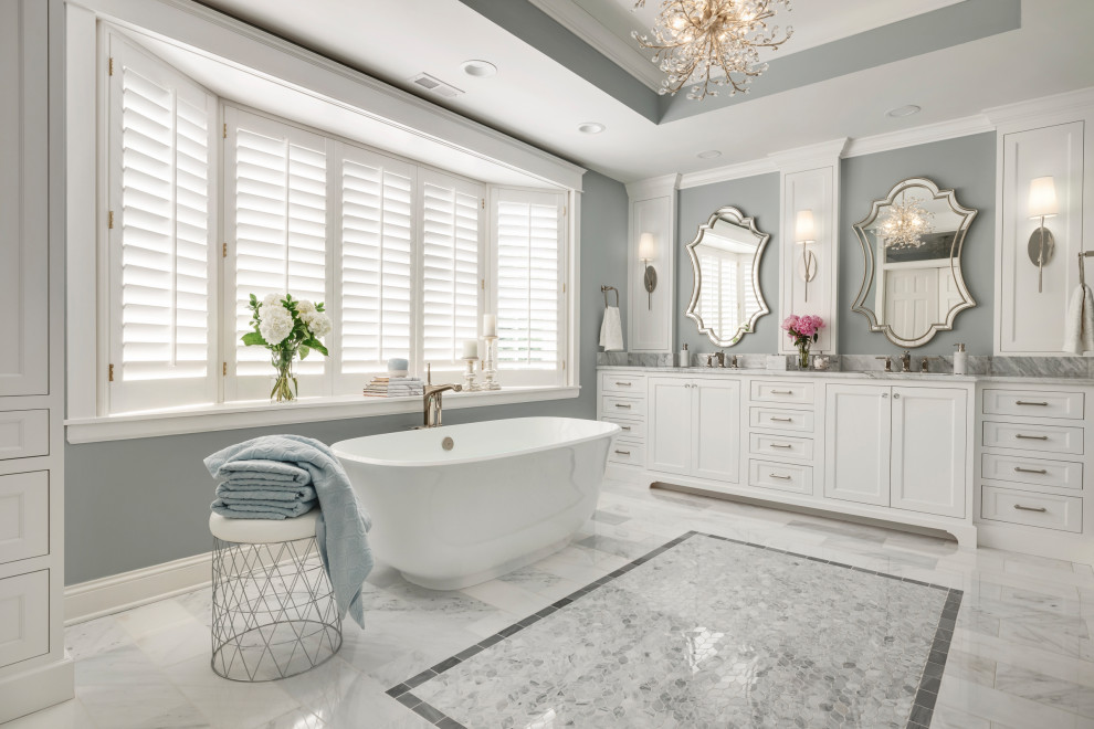 Design ideas for an expansive transitional master bathroom in Minneapolis with recessed-panel cabinets, white cabinets, a freestanding tub, an alcove shower, white tile, marble, blue walls, marble floors, an undermount sink, marble benchtops, white floor, an open shower, white benchtops, an enclosed toilet, a double vanity, a built-in vanity and recessed.