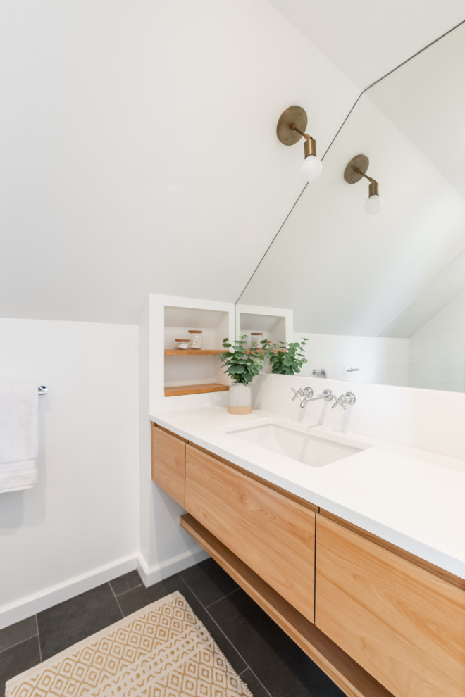 Идея дизайна: маленькая ванная комната в современном стиле с плоскими фасадами, светлыми деревянными фасадами, душем в нише, унитазом-моноблоком, белой плиткой, плиткой из листового камня, белыми стенами, полом из керамогранита, душевой кабиной, врезной раковиной, столешницей из кварцита, серым полом, душем с распашными дверями, белой столешницей, тумбой под одну раковину и подвесной тумбой для на участке и в саду