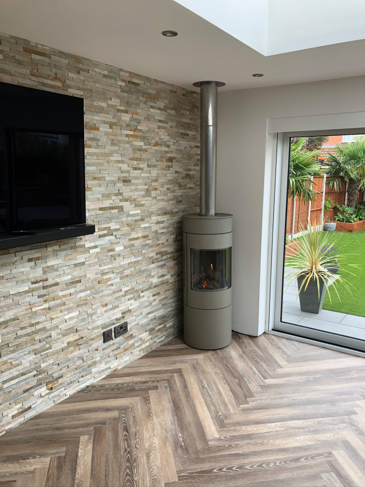 Photo of a mid-sized contemporary sunroom in West Midlands with ceramic floors, a corner fireplace, a standard ceiling and brown floor.