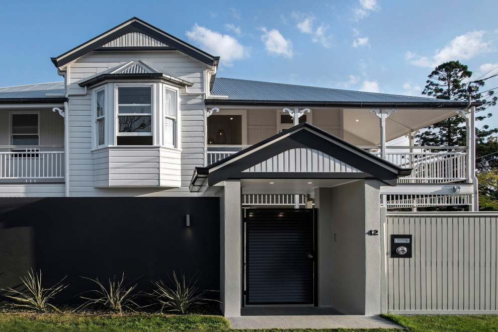 This is an example of a contemporary two-storey house exterior with mixed siding, a gable roof and a metal roof.