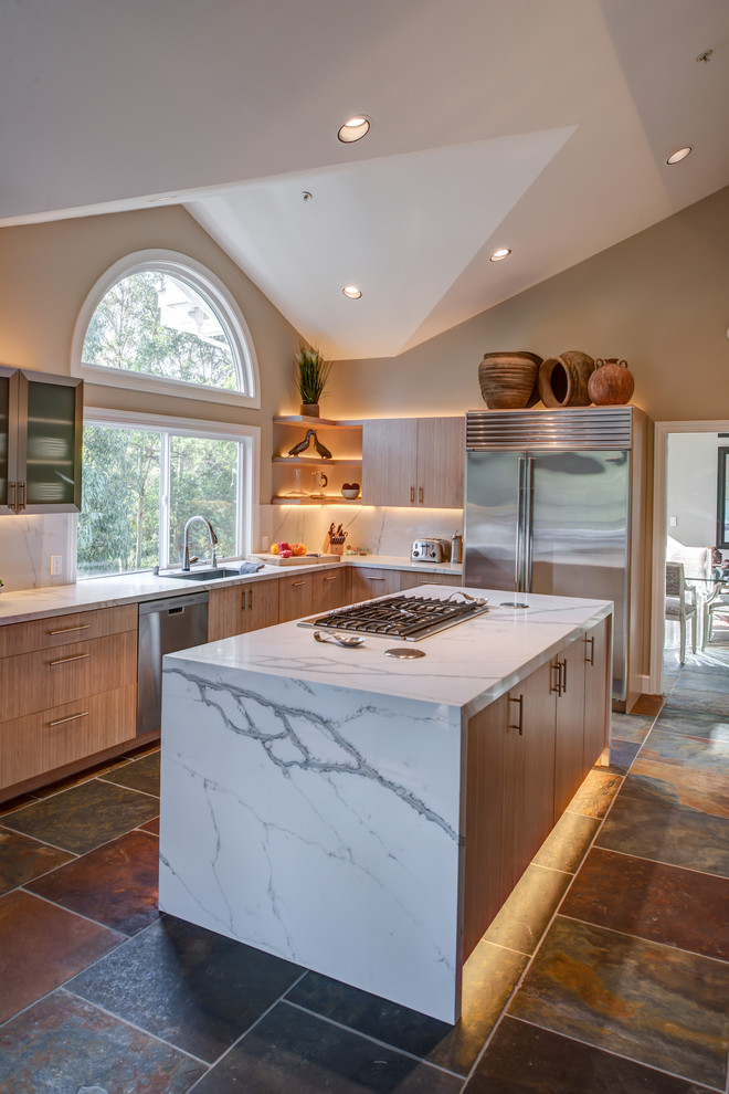 This is an example of a mid-sized contemporary l-shaped open plan kitchen in San Francisco with flat-panel cabinets, quartz benchtops, stainless steel appliances, with island, an undermount sink, light wood cabinets, slate floors, multi-coloured splashback and slate splashback.