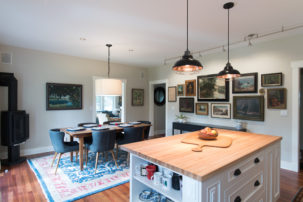 Example of a mid-sized transitional l-shaped medium tone wood floor and brown floor eat-in kitchen design in Seattle with an undermount sink, recessed-panel cabinets, white cabinets, quartz countertops, white backsplash, ceramic backsplash, stainless steel appliances, an island and white countertops