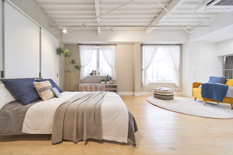 Contemporary bedroom in Tokyo with beige walls, light hardwood flooring and beige floors.