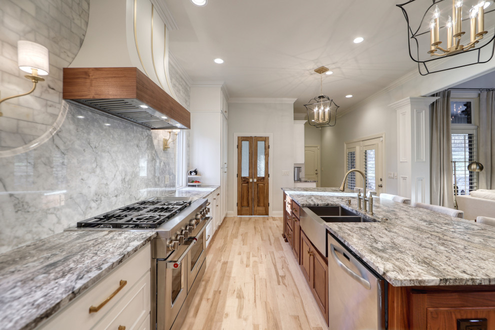 This is an example of a large eclectic l-shaped kitchen/diner in Nashville with a belfast sink, beaded cabinets, white cabinets, granite worktops, grey splashback, marble splashback, stainless steel appliances, an island and grey worktops.