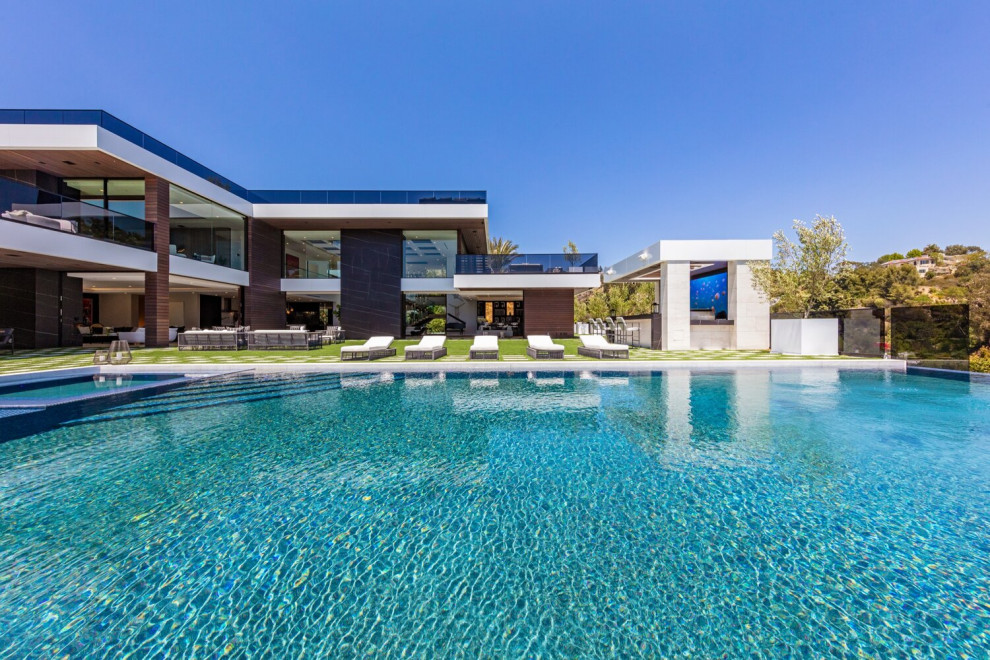 Large modern backyard rectangular infinity pool in Los Angeles with with a pool.
