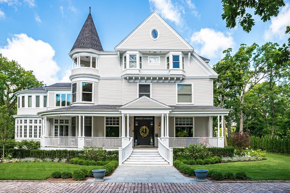 Example of an ornate gray three-story wood gable roof design in Chicago