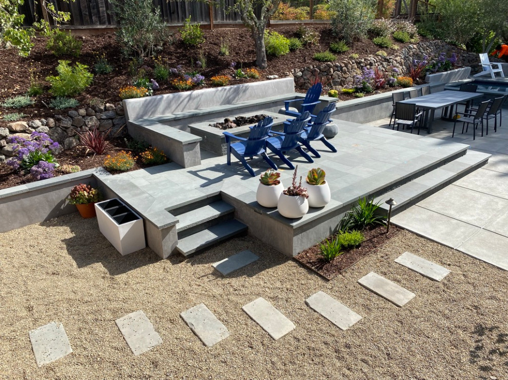 Idee per un giardino moderno esposto in pieno sole di medie dimensioni e dietro casa in autunno con un focolare, pavimentazioni in pietra naturale e recinzione in legno