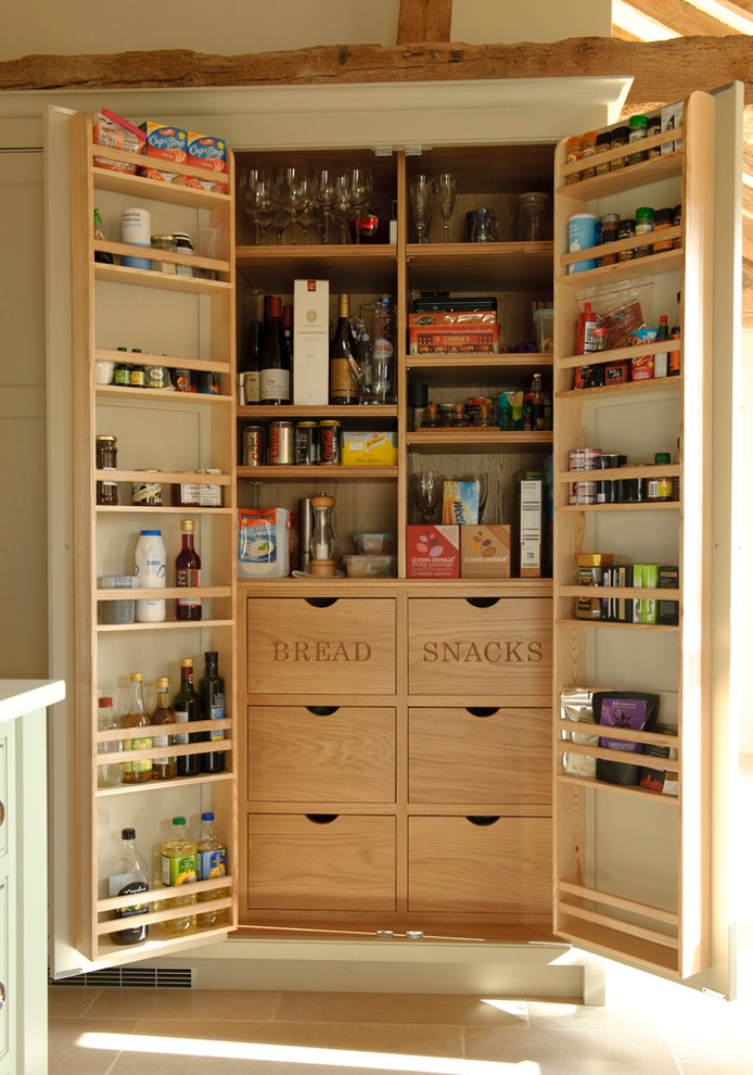 Photo of a mid-sized contemporary kitchen pantry in Hampshire with shaker cabinets, beige cabinets, stainless steel appliances, limestone floors and with island.