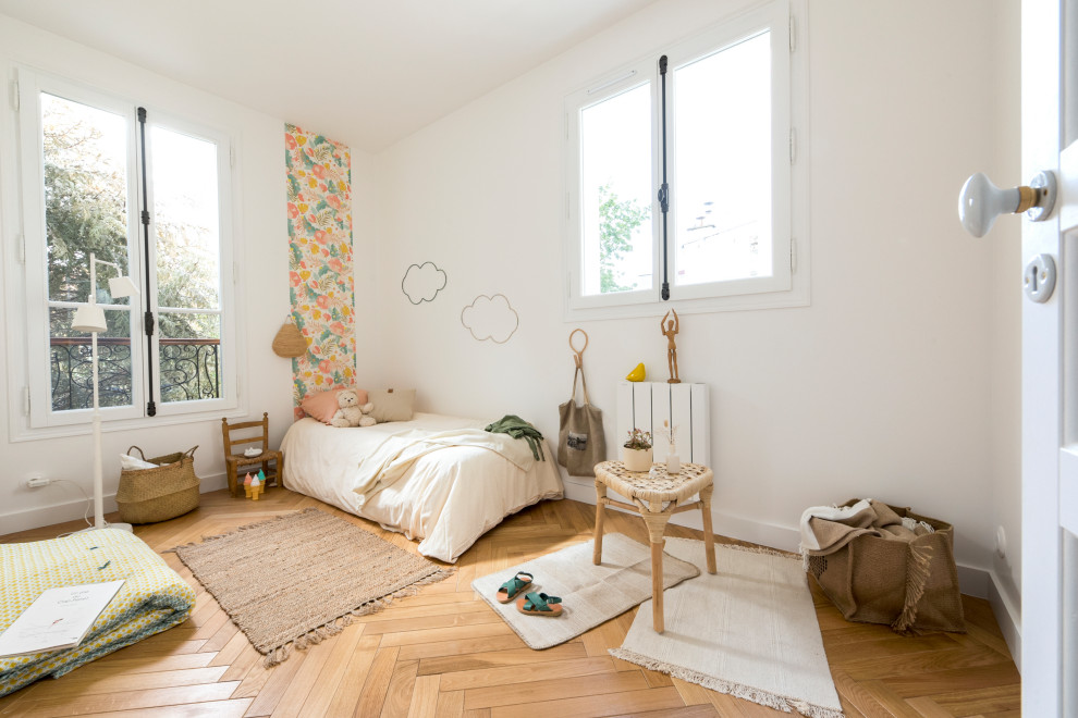 Mid-sized kids' bedroom in Paris with light hardwood floors for kids 4-10 years old and girls.