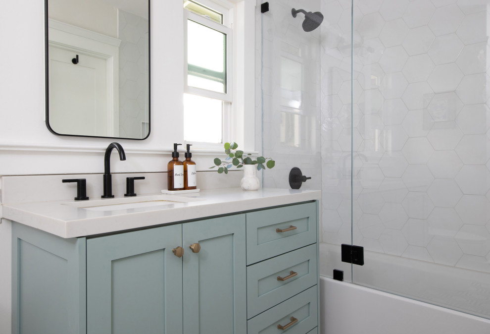 Идея дизайна: главная ванная комната среднего размера в стиле ретро с фасадами в стиле шейкер, зелеными фасадами, ванной в нише, душем в нише, унитазом-моноблоком, белой плиткой, керамогранитной плиткой, белыми стенами, полом из мозаичной плитки, врезной раковиной, столешницей из искусственного кварца, разноцветным полом, душем с распашными дверями, белой столешницей, нишей, тумбой под одну раковину и встроенной тумбой