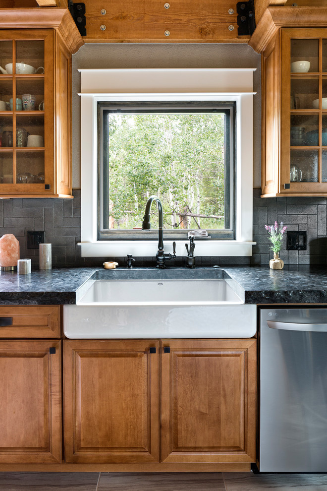 Inspiration for a mid-sized rustic u-shaped dark wood floor and brown floor eat-in kitchen remodel in Denver with a farmhouse sink, glass-front cabinets, medium tone wood cabinets, granite countertops, gray backsplash, ceramic backsplash, stainless steel appliances and no island