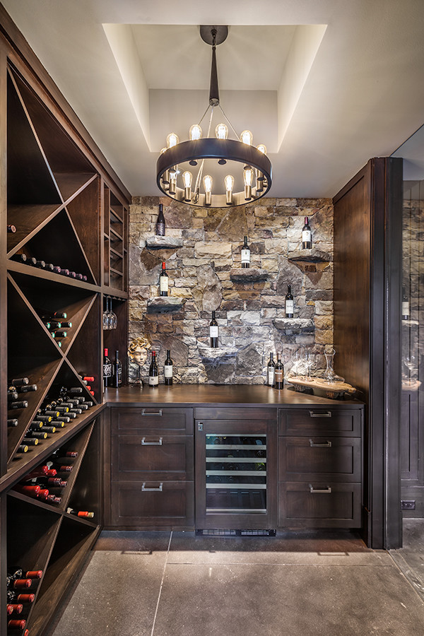 Photo of a large country wine cellar in Other with concrete floors, diamond bins and grey floor.