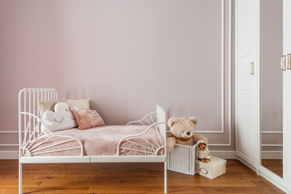Foto de dormitorio infantil de 1 a 3 años actual de tamaño medio con paredes rosas, suelo de madera en tonos medios, suelo marrón y papel pintado