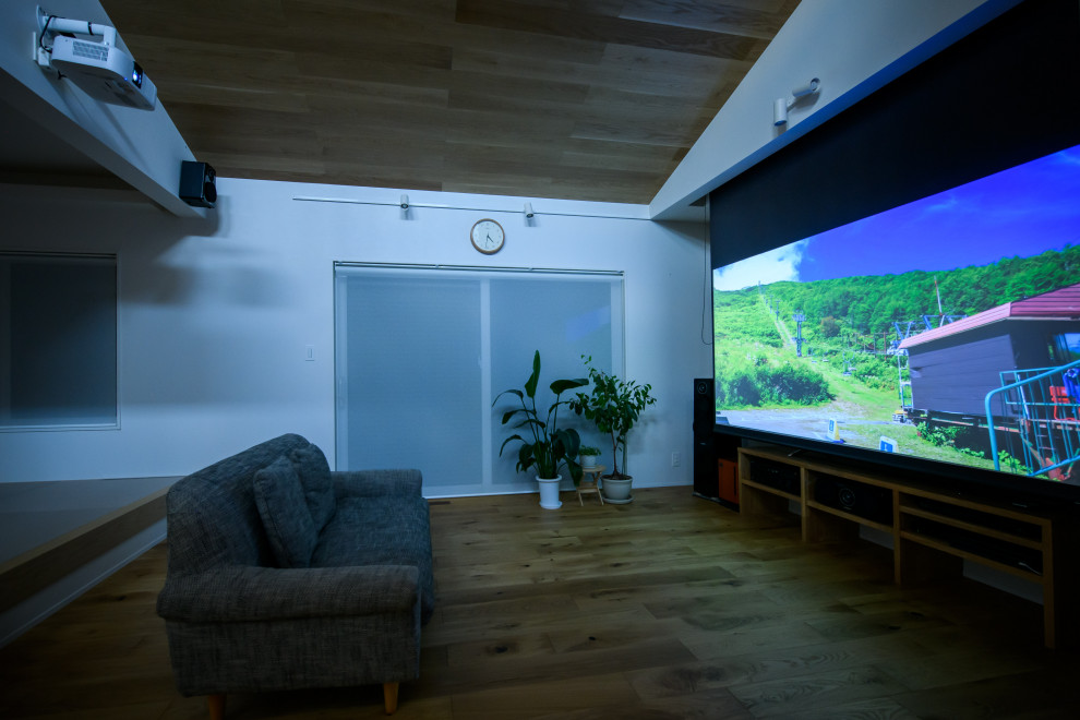 Foto de cine en casa moderno con paredes blancas, suelo de madera en tonos medios y pantalla de proyección