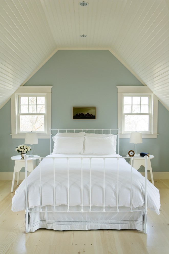 Photo of a beach style bedroom in Providence with light hardwood floors, blue walls and beige floor.