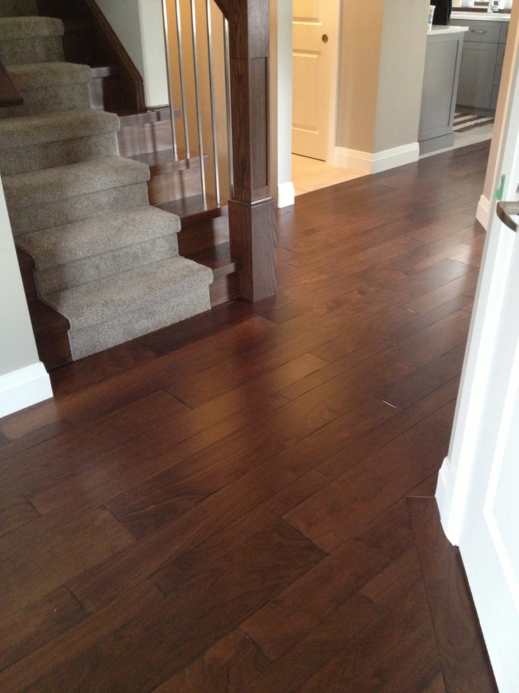 Large transitional medium tone wood floor hallway photo in Toronto with gray walls