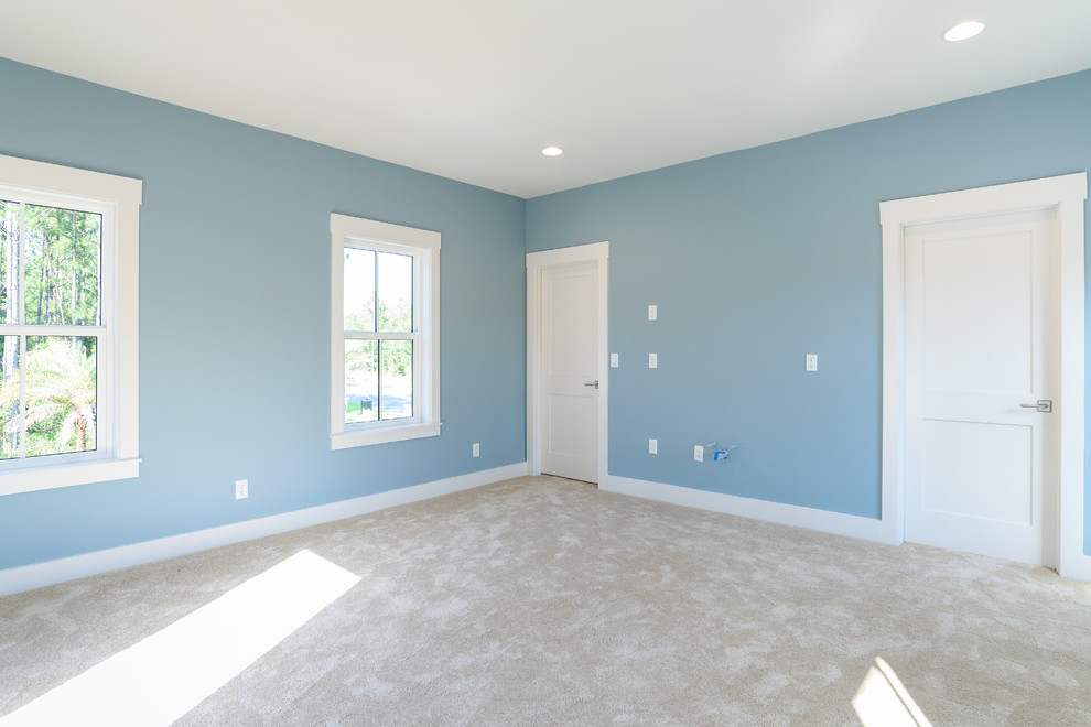 Mid-sized beach style bedroom in Jacksonville with blue walls, carpet and beige floor.