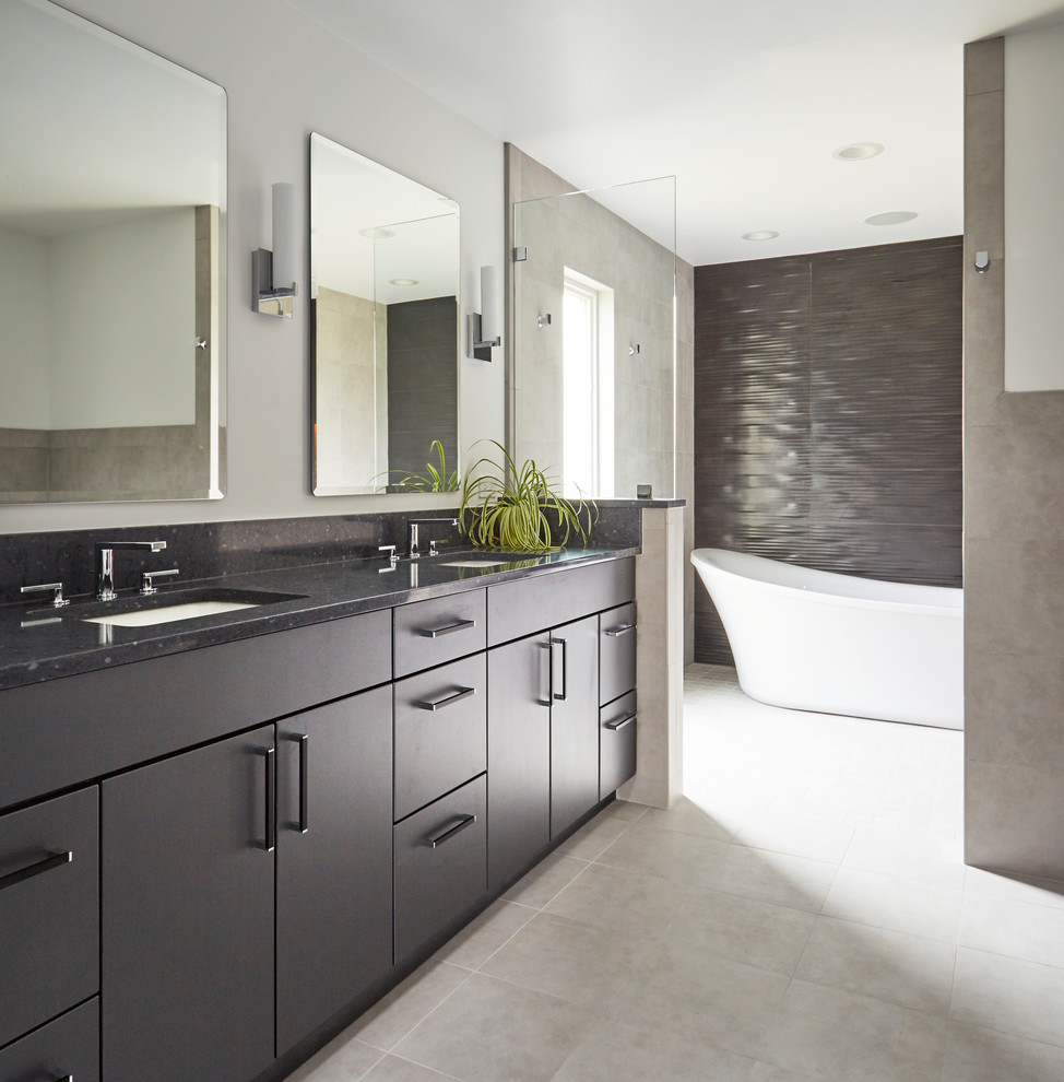 This is an example of a contemporary bathroom in Chicago with flat-panel cabinets, grey cabinets, a freestanding tub, gray tile, an undermount sink, grey floor and grey benchtops.