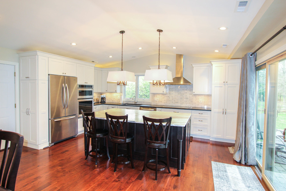 Inspiration for a mid-sized transitional l-shaped medium tone wood floor eat-in kitchen remodel in Cincinnati with an undermount sink, recessed-panel cabinets, white cabinets, quartzite countertops, white backsplash, subway tile backsplash, stainless steel appliances and an island