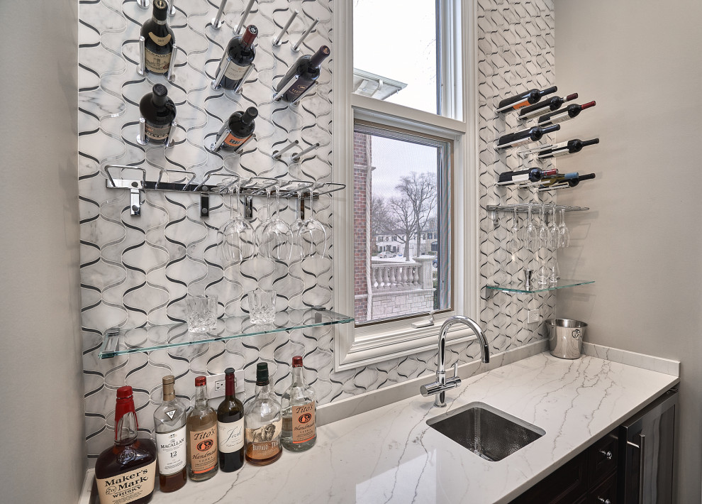 Inspiration for a medium sized classic single-wall wet bar in Chicago with a submerged sink, recessed-panel cabinets, dark wood cabinets, engineered stone countertops, white splashback, marble splashback, dark hardwood flooring, brown floors and white worktops.