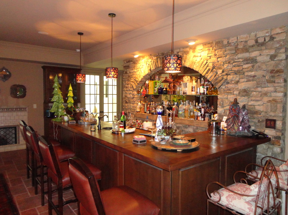 This is an example of a large traditional home bar in Atlanta with terra-cotta floors.