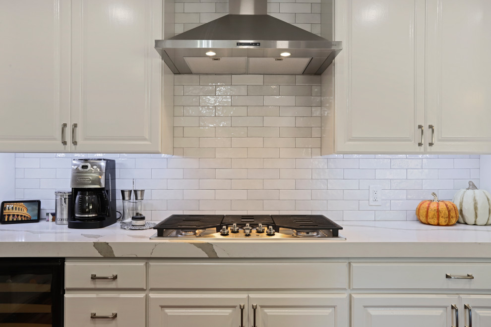 Inspiration for a contemporary u-shaped eat-in kitchen remodel in Sacramento with an undermount sink, white cabinets, quartz countertops, white backsplash, ceramic backsplash, stainless steel appliances, an island and white countertops