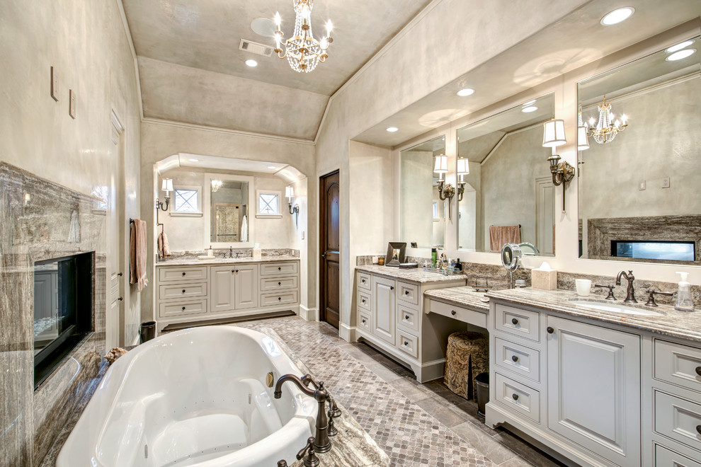 Design ideas for a mediterranean bathroom in Houston with an undermount sink, raised-panel cabinets, white cabinets, a drop-in tub, beige walls and grey benchtops.