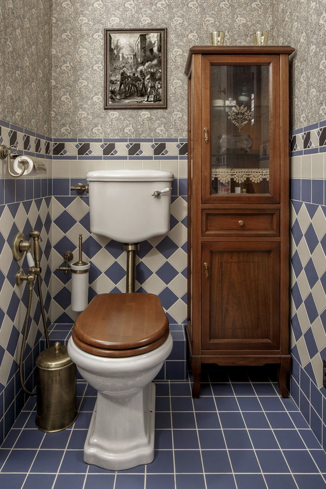 This is an example of a small traditional powder room in Other with a two-piece toilet, ceramic tile, grey walls, ceramic floors, blue floor, beige tile and blue tile.