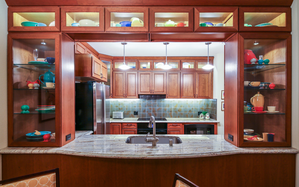 This is an example of a small modern galley separate kitchen in San Francisco with an undermount sink, glass-front cabinets, red cabinets, granite benchtops, grey splashback, ceramic splashback, stainless steel appliances, cork floors and brown floor.