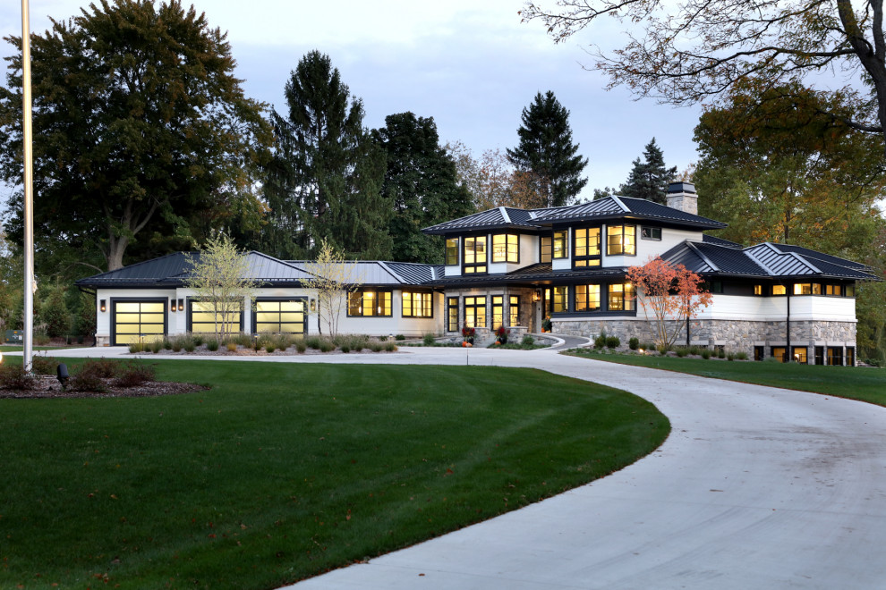 Aménagement d'une grande façade de maison blanche contemporaine à un étage avec un revêtement mixte, un toit à quatre pans, un toit en métal et un toit noir.