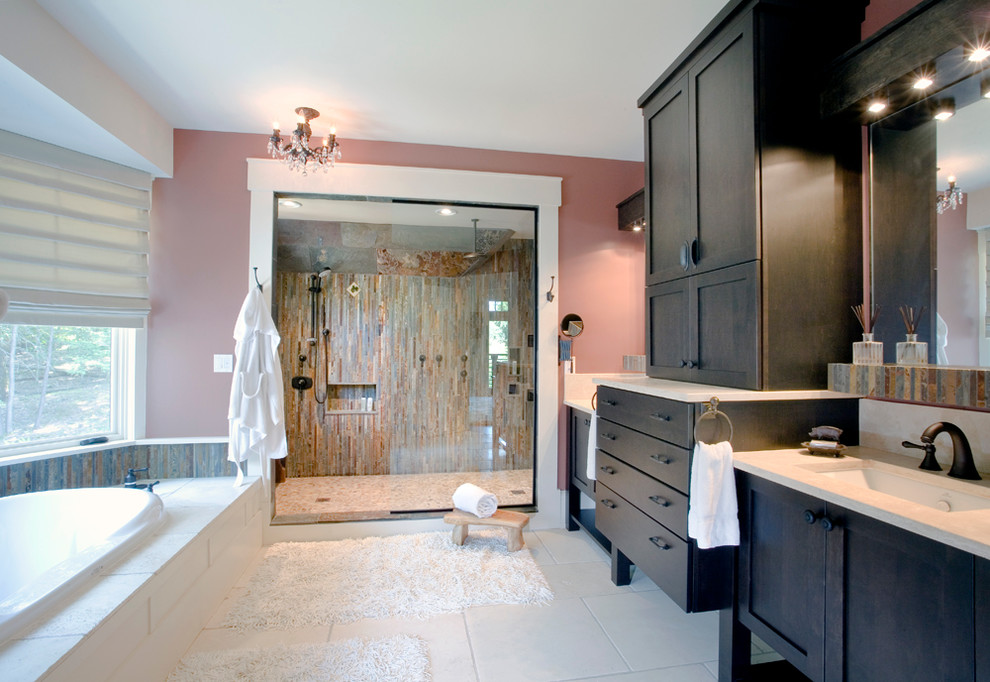 This is an example of a mid-sized transitional master bathroom in New York with shaker cabinets, dark wood cabinets, a drop-in tub, beige tile, stone tile, pink walls, travertine floors, an undermount sink, soapstone benchtops, an alcove shower, white floor and a hinged shower door.