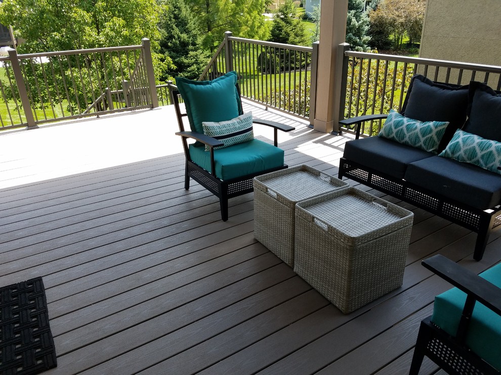 This is an example of a mid-sized contemporary backyard deck in Kansas City with a roof extension.