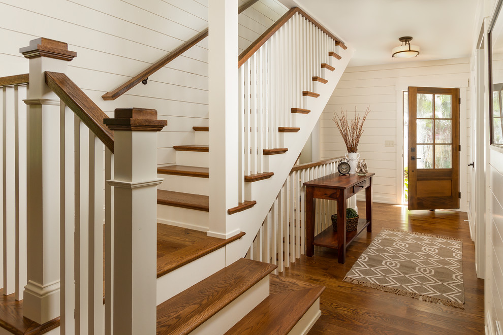 Photo of a large traditional foyer in Minneapolis with white walls, dark hardwood floors, a single front door, a dark wood front door and brown floor.