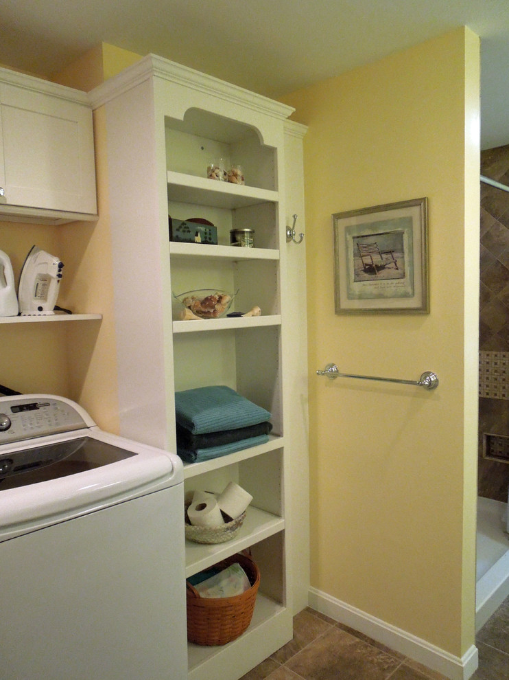 Mid-sized traditional l-shaped utility room in Charleston with an undermount sink, recessed-panel cabinets, white cabinets, granite benchtops, yellow walls, porcelain floors and a side-by-side washer and dryer.