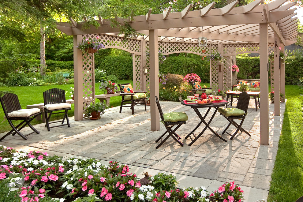Photo of a traditional backyard patio in Other with natural stone pavers.