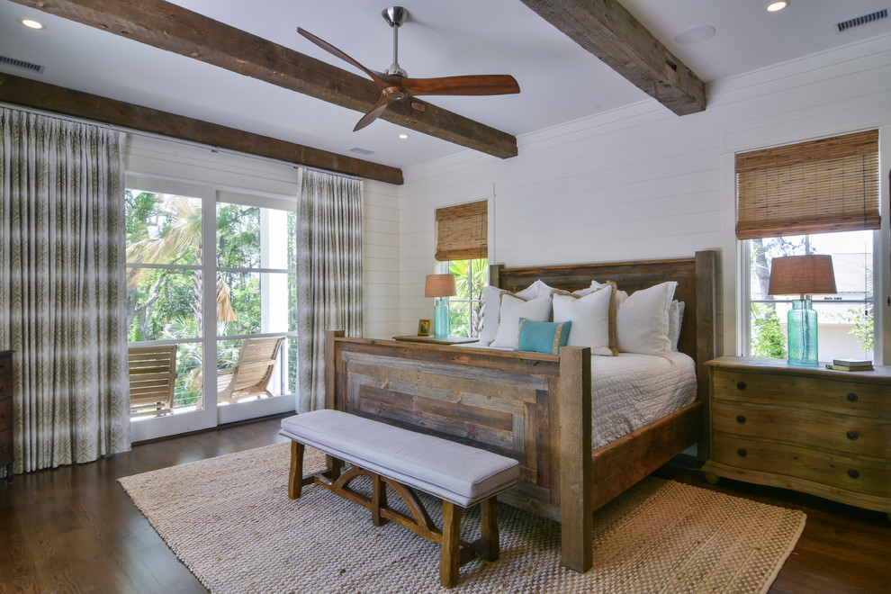 Inspiration for a mid-sized beach style master bedroom in Charleston with white walls, dark hardwood floors and brown floor.