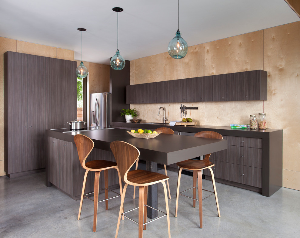 Photo of a mid-sized contemporary galley eat-in kitchen in Austin with flat-panel cabinets, laminate benchtops, stainless steel appliances, concrete floors, with island, a single-bowl sink, dark wood cabinets, brown splashback, timber splashback and grey floor.