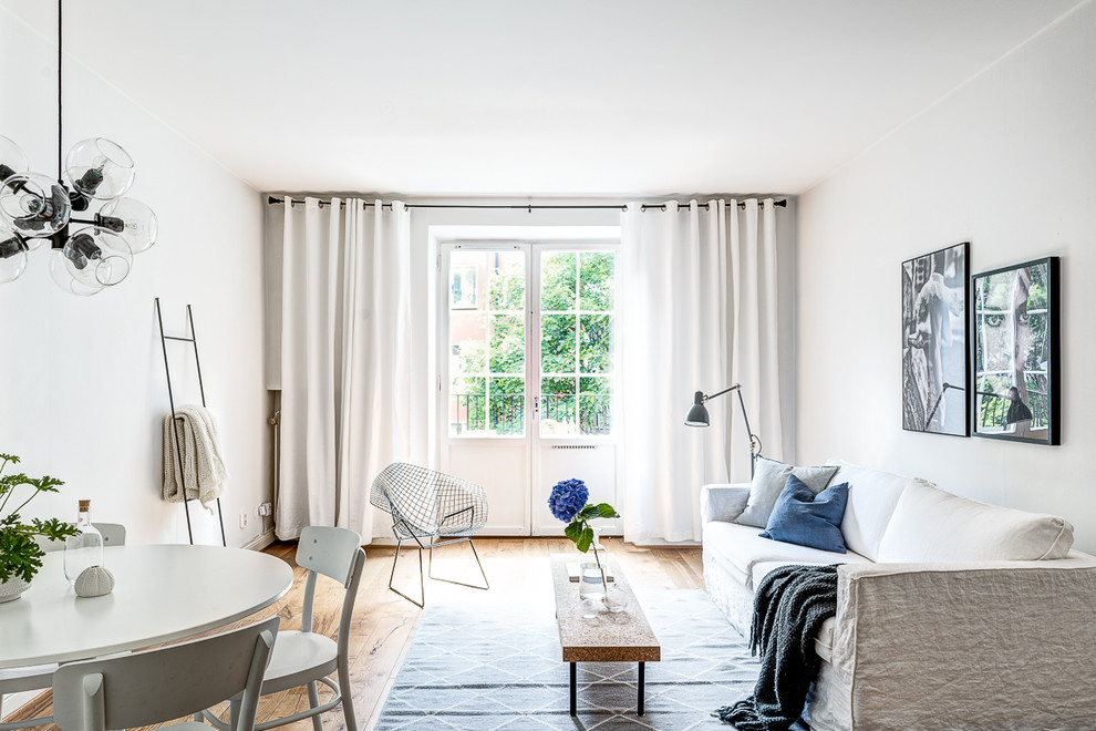 Minimalistisk inredning av ett allrum med öppen planlösning, med vita väggar