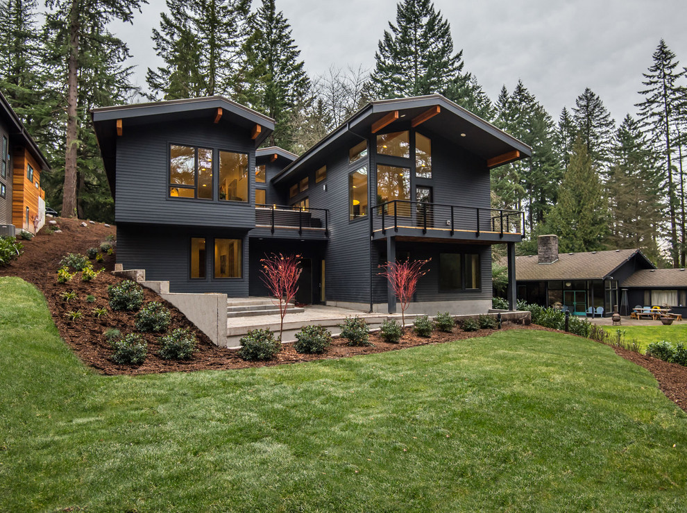 This is an example of a midcentury two-storey black house exterior in Portland.