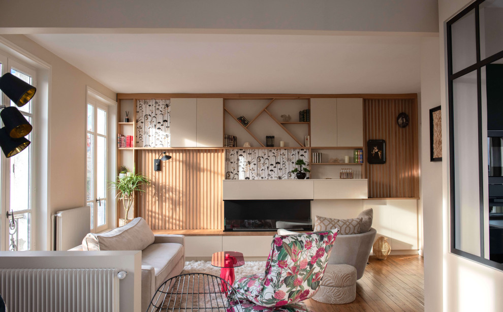 Aménagement d'un petit salon classique ouvert avec une bibliothèque ou un coin lecture, un mur beige, un sol en bois brun et une cheminée double-face.