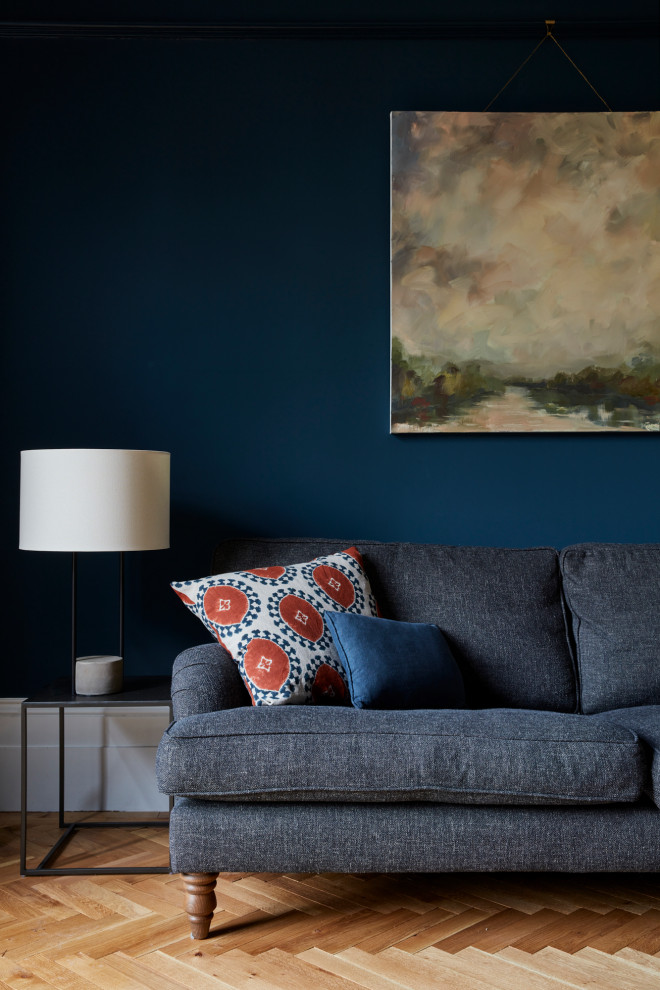 Idee per un grande soggiorno vittoriano con pareti blu, pavimento in legno massello medio, camino classico e con abbinamento di mobili antichi e moderni